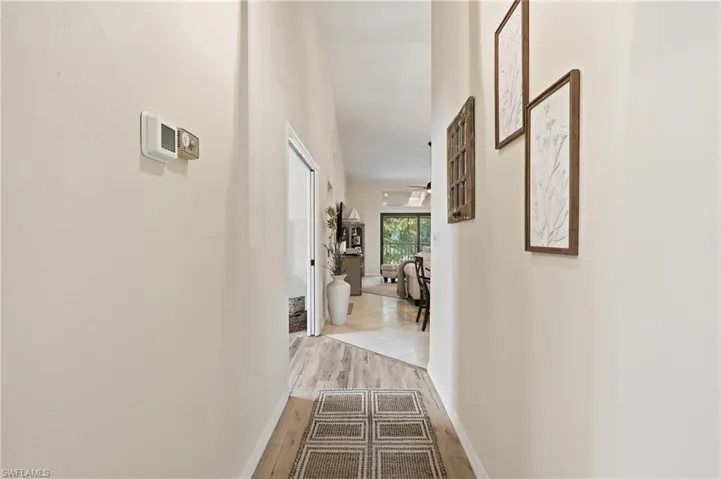 Vaulted ceiling with wood-finish flooring transitioning to tile