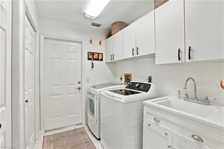 Laundry room with plenty of cabinetry and utility sink.