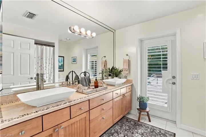 Guest bath with a spacious vanity and lanai access.