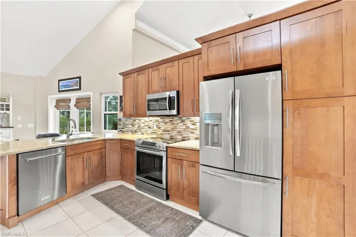 Kitchen with warm wood cabinetry, stainless steel appliances and generous storage.