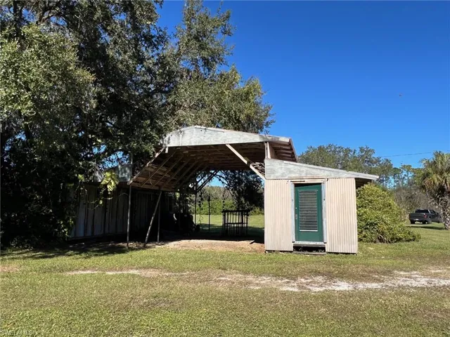 View of yard with a carport and a storage shed