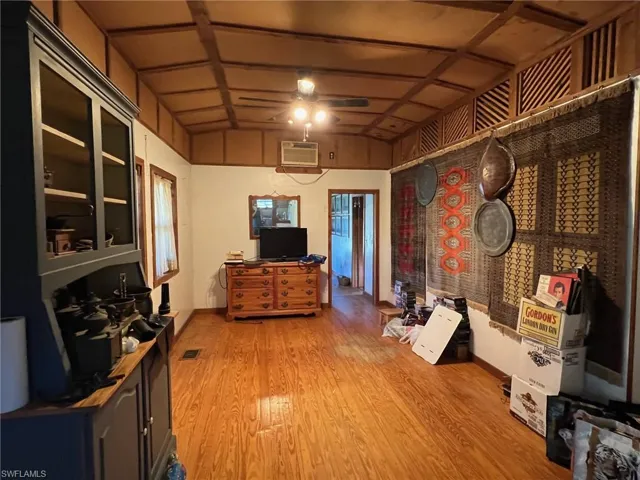 Miscellaneous room featuring a wall unit AC, ceiling fan, hardwood / wood-style floors, and lofted ceiling