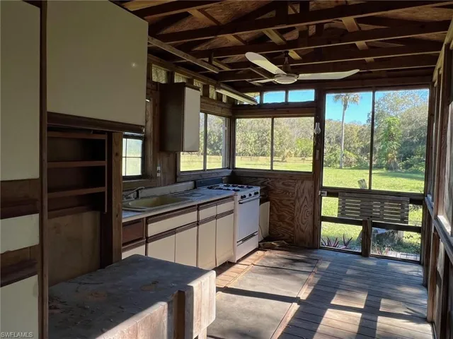 Sunroom / solarium featuring ceiling fan, sink, and vaulted ceiling