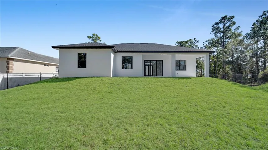 Back of property featuring a fenced backyard, stucco siding, and a shingled roof