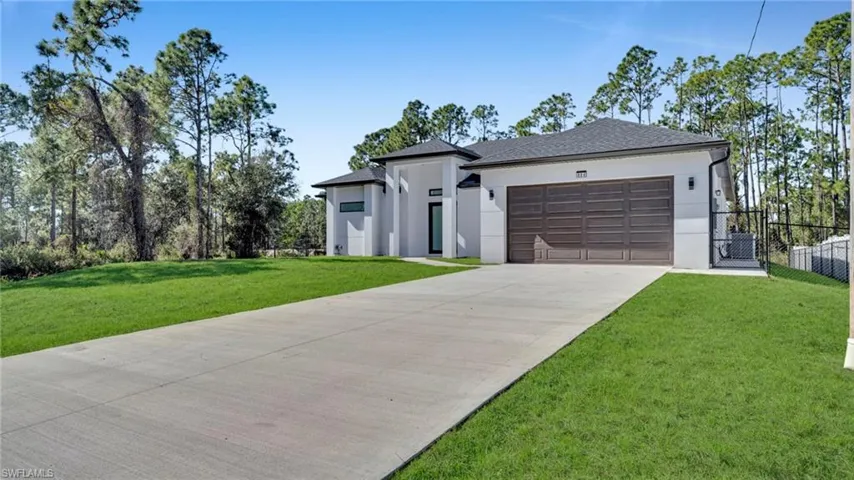 View of front of home with stucco siding, driveway, a garage, and a shingled roof
