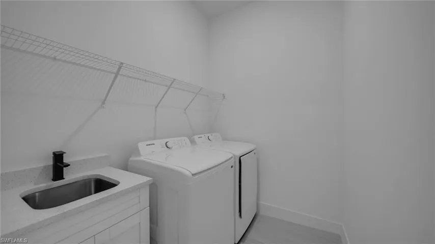 Laundry room with washer and  dryer and baseboards
