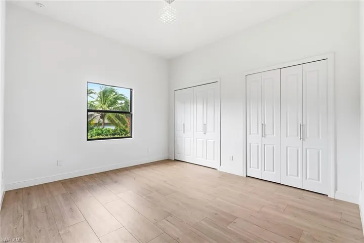 Recessed lighting, wood-finish flooring, and dual bi-fold closet doors