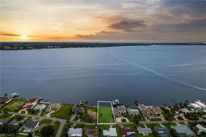 Aerial view at dusk featuring a water view