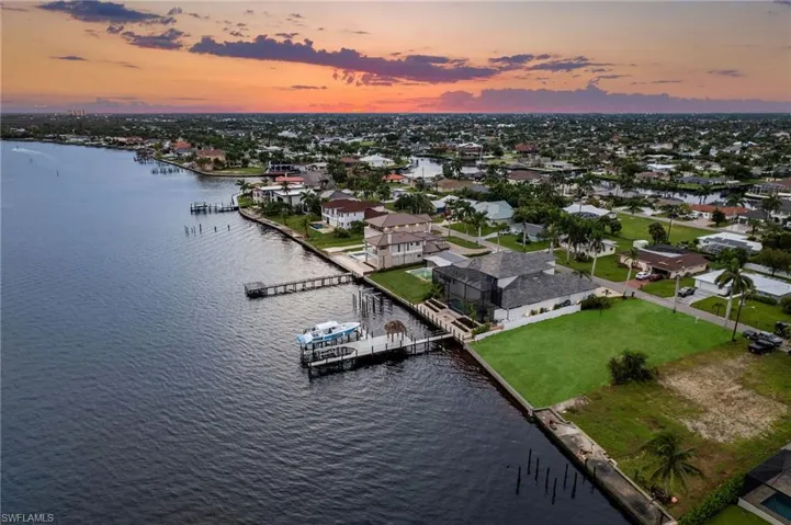 Aerial view at dusk featuring a water view
