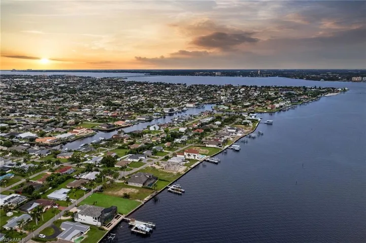 Aerial view at dusk featuring a water view