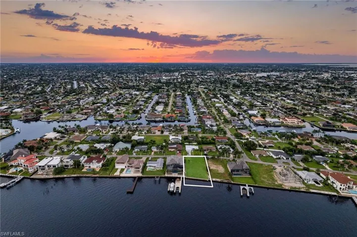 Aerial view at dusk featuring a water view