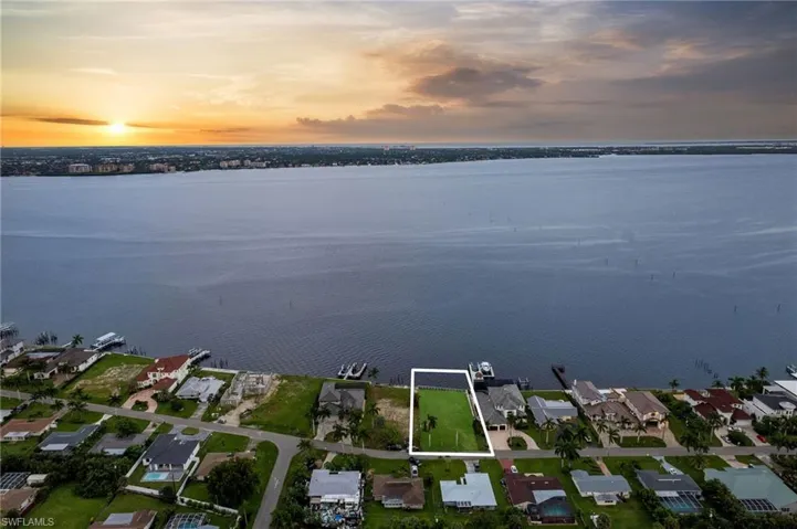 Aerial view at dusk featuring a water view