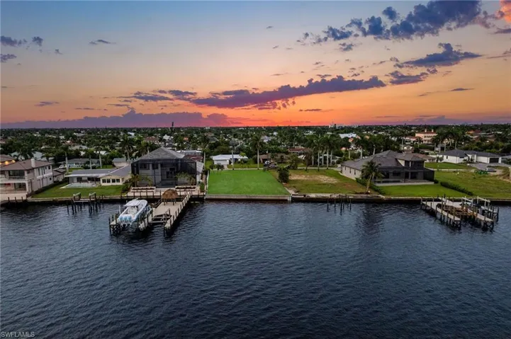 Aerial view at dusk featuring a water view