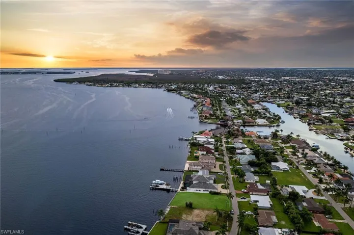 Aerial view at dusk featuring a water view