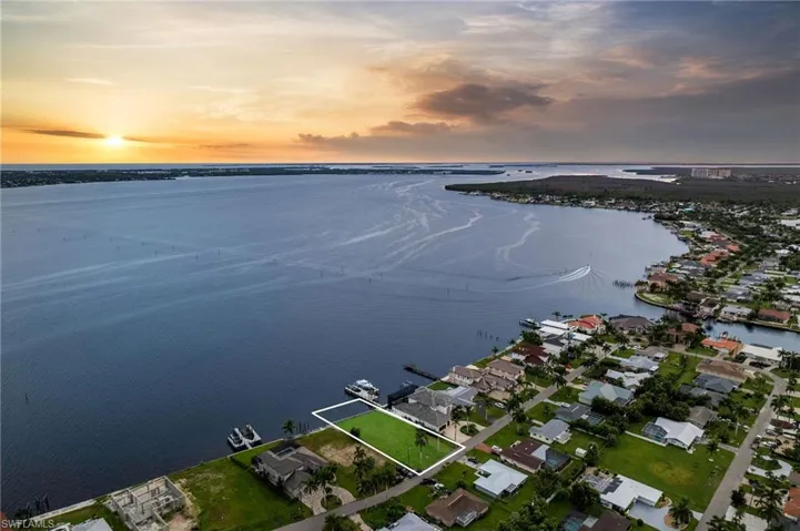 Aerial view at dusk featuring a water view