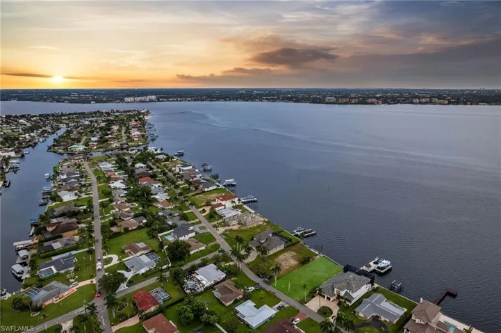 Aerial view at dusk featuring a water view