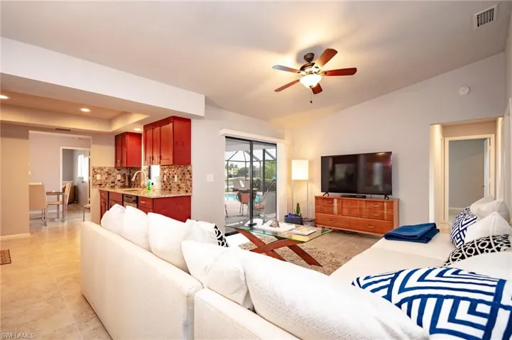 Open-concept living space featuring vaulted ceilings, a ceiling fan, and tile flooring
