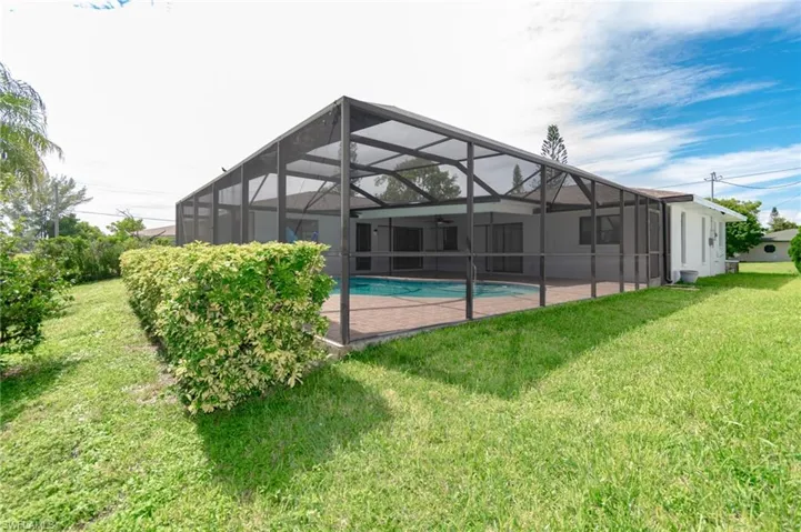 Screened-in pool enclosure featuring a rectangular pool and a paved deck