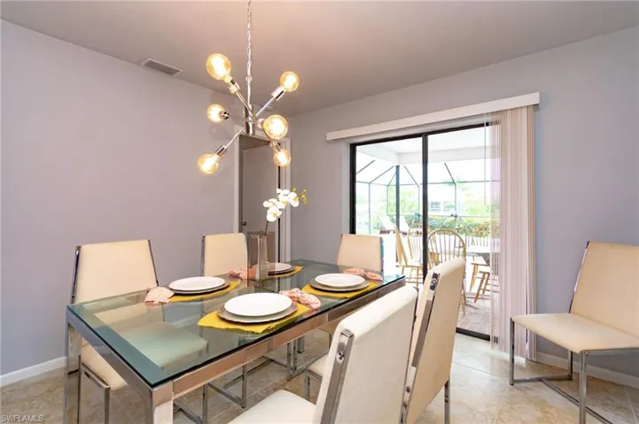 Dining area featuring a contemporary sputnik chandelier, light grey wall paint, and tile flooring