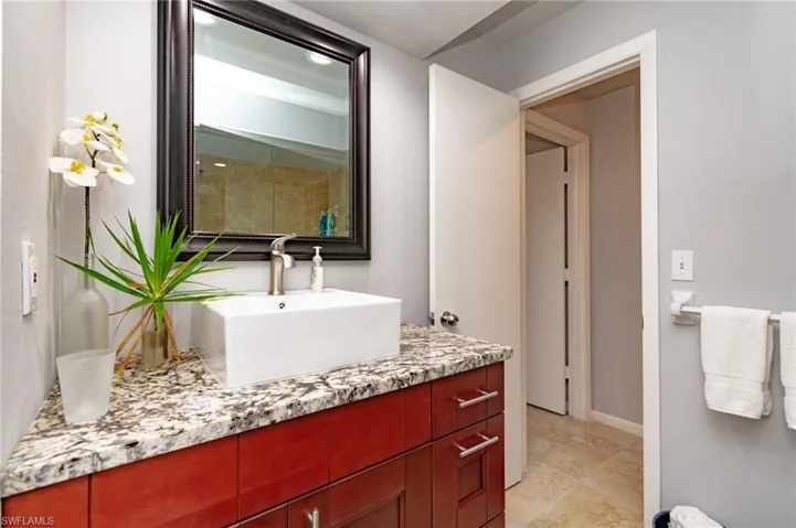Bathroom vanity featuring a rectangular vessel sink, brushed nickel faucet, and a granite-style countertop