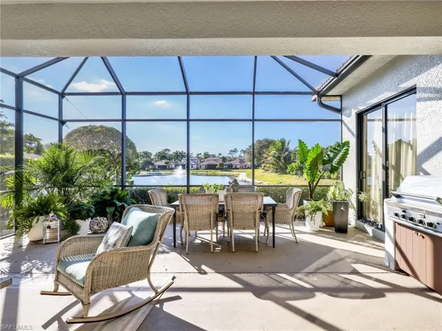 View of patio / terrace featuring a sunroom, a water view, outdoor dining space, glass enclosure, and area for grilling