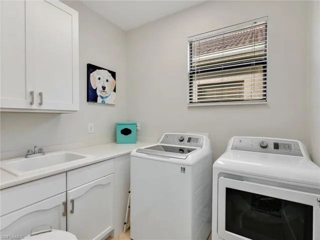 Washroom with washing machine and clothes dryer and cabinet space