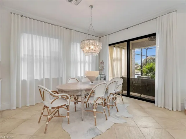 Dining room featuring plenty of natural light, crown molding, a chandelier, and light tile patterned floors
