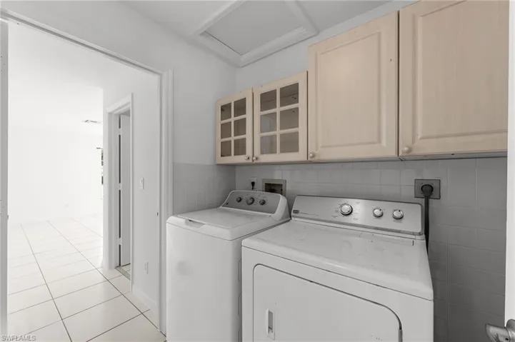 Laundry room featuring cabinet space, separate washer and dryer, and light tile patterned floors