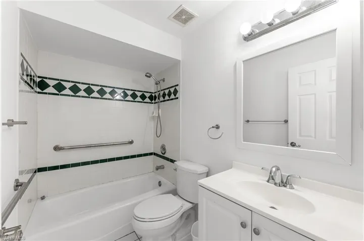 Bathroom featuring vanity and washtub / shower combination