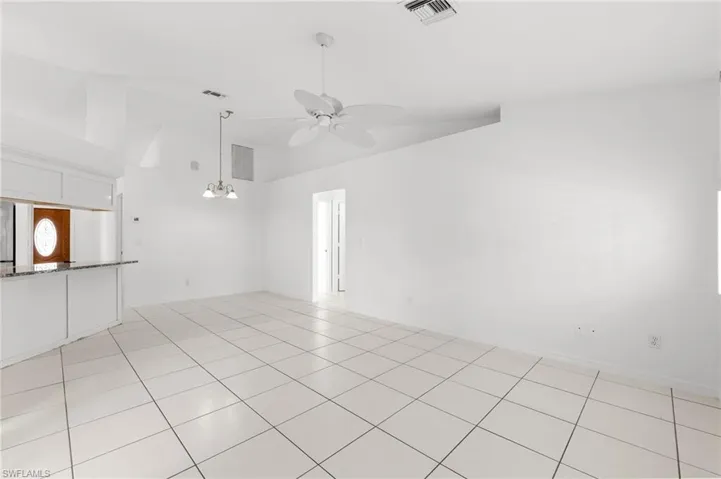 Spare room with a ceiling fan, light tile patterned floors, and suspended lighting