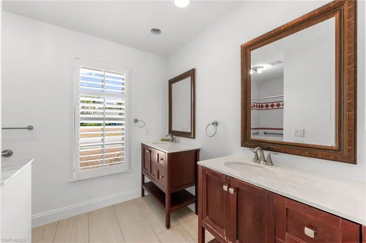 Full bathroom with two vanities and curtained shower