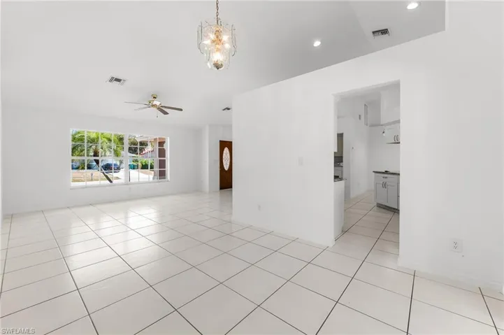 Unfurnished room featuring suspended lighting, light tile patterned flooring, and a ceiling fan