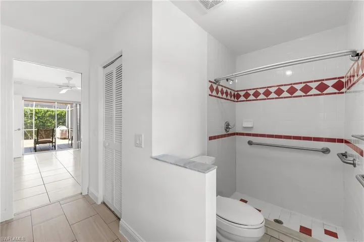 Full bath featuring a shower stall, a closet, and light tile patterned floors