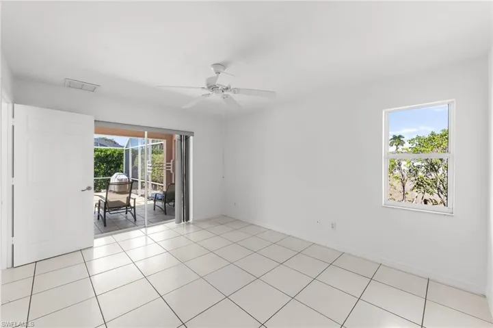 Empty room featuring a ceiling fan, healthy amount of natural light, and light tile patterned floors