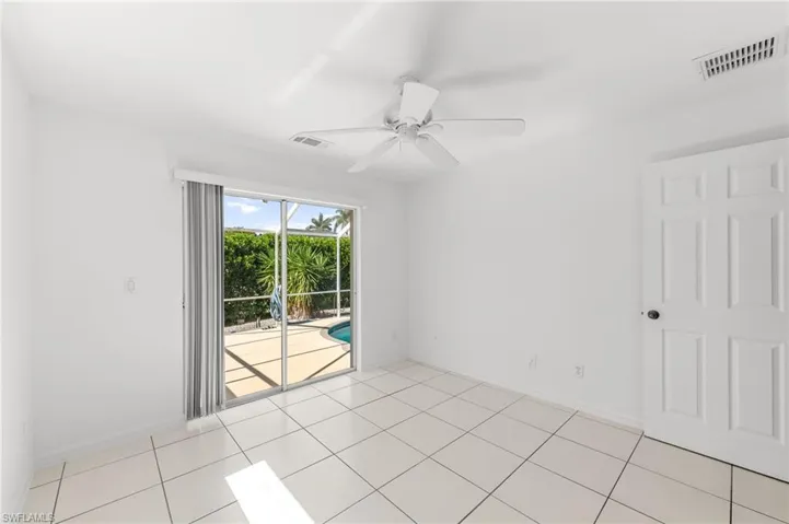 Empty room with ceiling fan and light tile patterned flooring