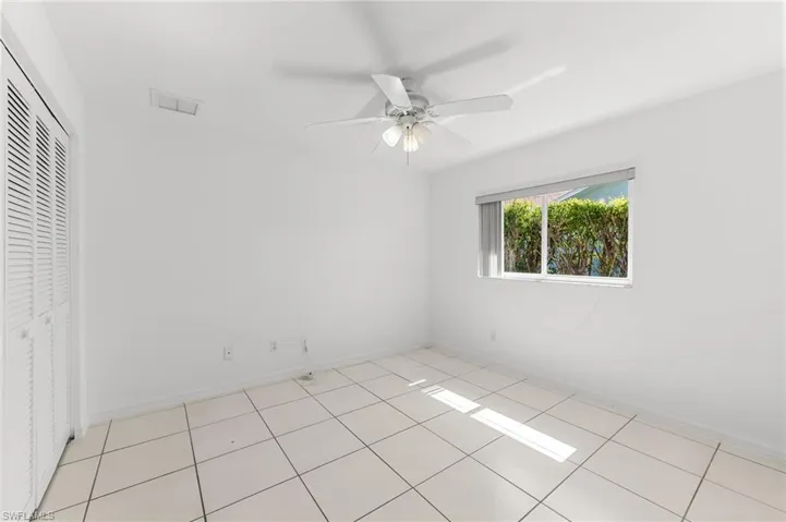 Unfurnished bedroom featuring a ceiling fan, a closet, and light tile patterned floors