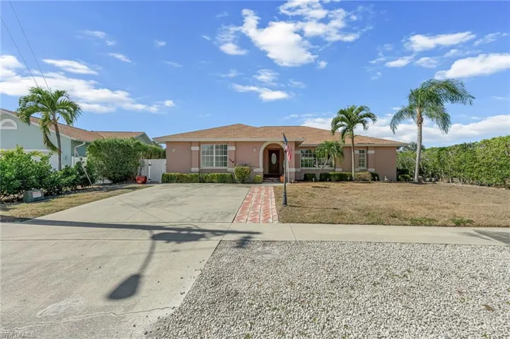 Ranch-style home featuring stucco siding, concrete driveway, and a front lawn