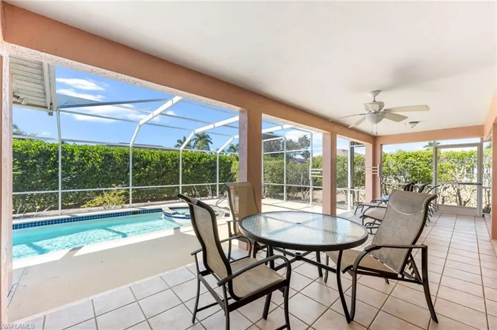 Sunroom / solarium with a patio area, a ceiling fan, outdoor dining space, and a swimming pool