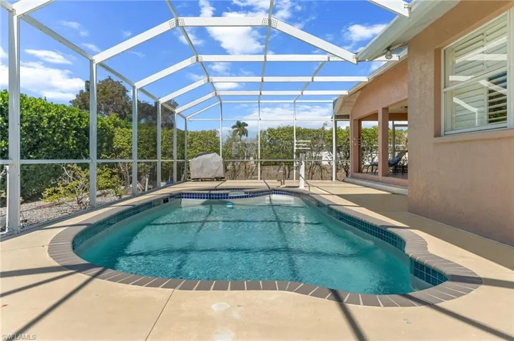Swimming pool featuring a patio area, a sunroom, and glass enclosure