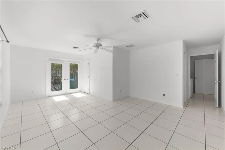 Empty room with french doors, a ceiling fan, and light tile patterned floors