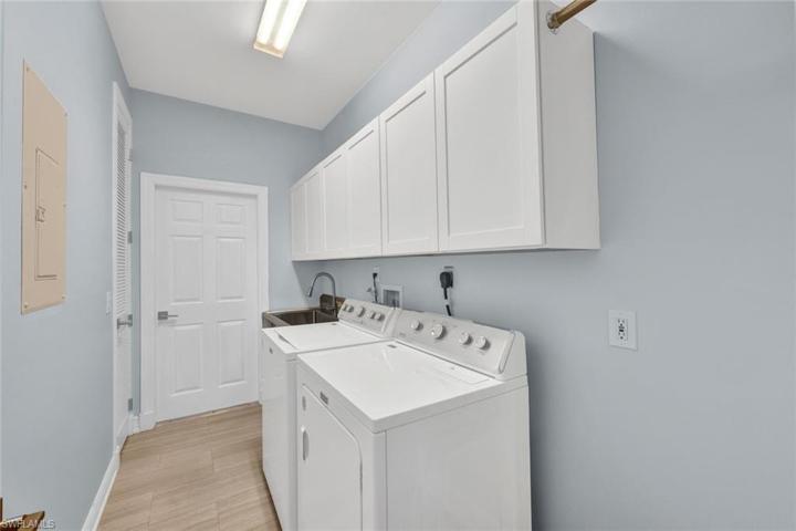 Laundry room as you enter from the spacious two car garage with stainless steel sink and plenty of cabinet space and closet.