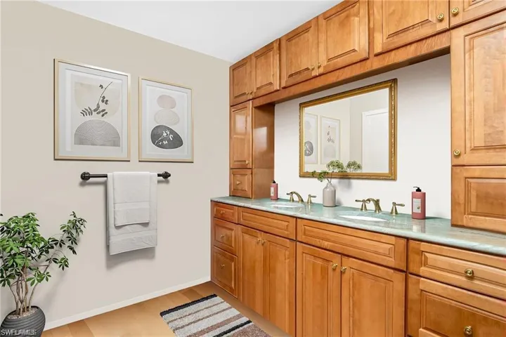 Bathroom featuring double vanity and light wood finished floors