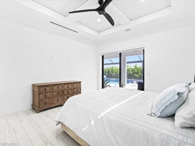 Bedroom with access to outside, ceiling fan, light wood-style flooring, a sunroom, and coffered ceiling
