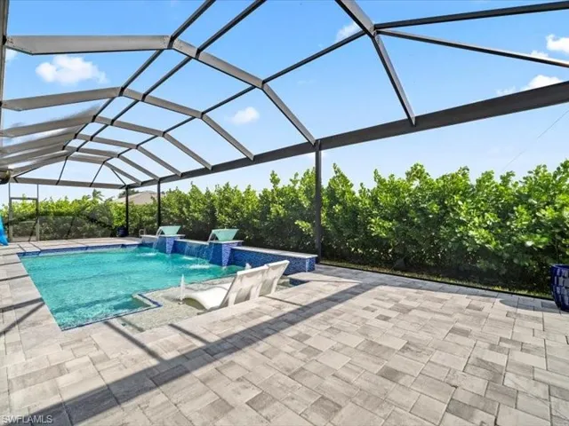 Swimming pool with a lanai, a sunroom, and a patio area