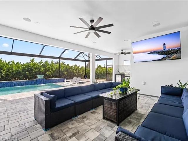 View of patio featuring an outdoor living space, ceiling fan, glass enclosure, an outdoor pool, and a sunroom