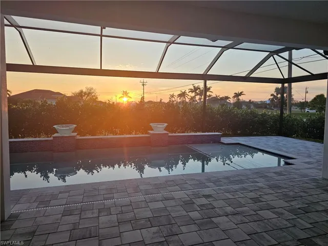 Outdoor pool featuring glass enclosure and a patio area