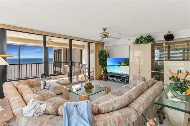 Living room with ceiling fan and a textured ceiling