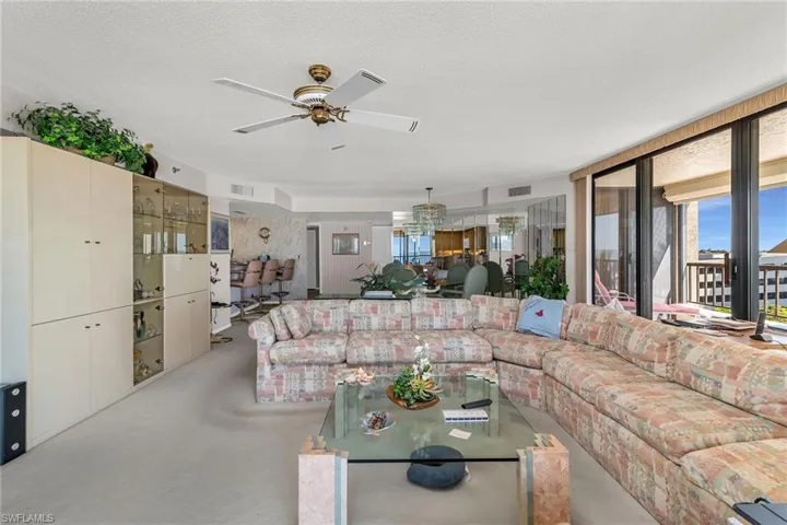 Living area with a textured ceiling, visible vents, and finished concrete floors