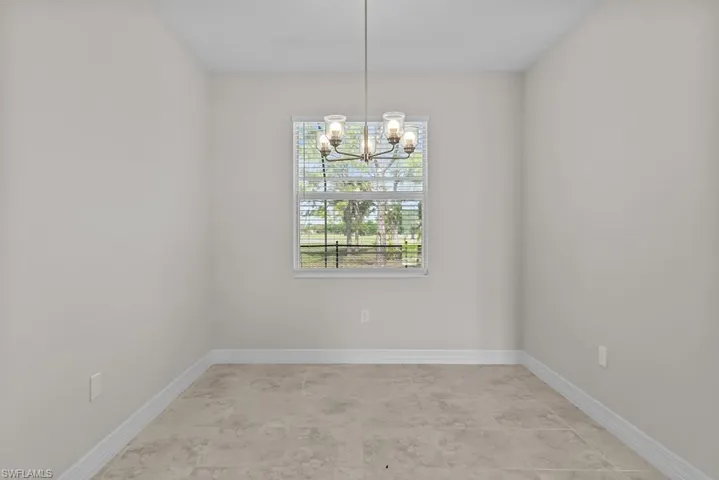 Empty room featuring suspended lighting and baseboards