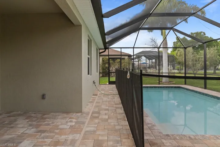 Outdoor pool featuring a patio area, a sunroom, a lanai, and a yard